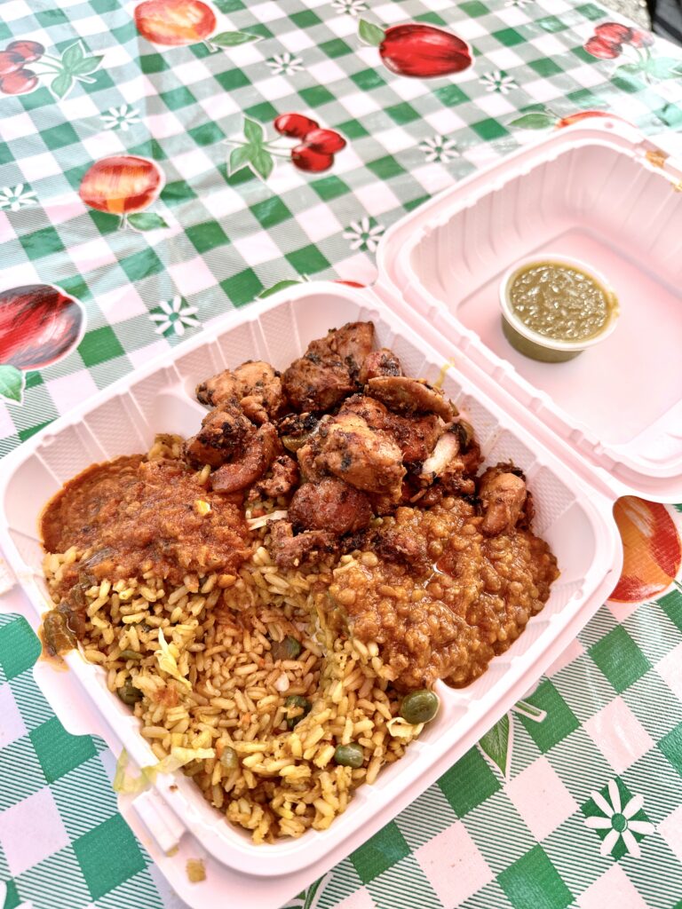 container of a cultural meal of chicken, lentils, and rice on a colorful tablecloth to encourage variety and new foods